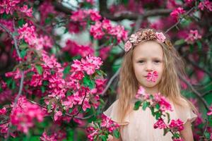 retrato de menina em lindo jardim de maçã florescendo ao ar livre foto