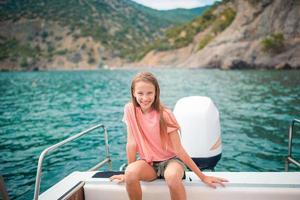 adorável garota navegando no barco em mar aberto claro nas férias de verão foto