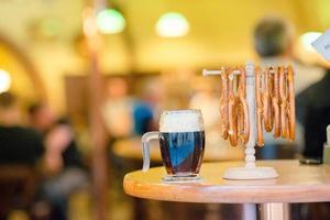 feche pretzels saborosos salgados e cerveja no fundo de madeira. foto