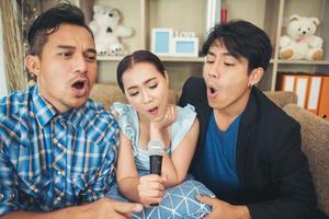 grupo de amigos cantando uma música juntos na sala de estar foto