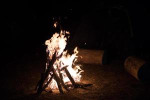 fogueira de acampamento na noite escura foto