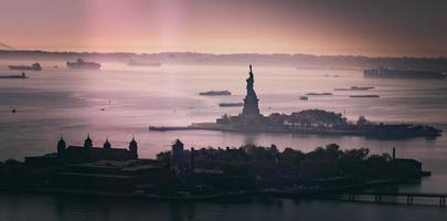 silhueta da estátua da liberdade ao pôr do sol foto