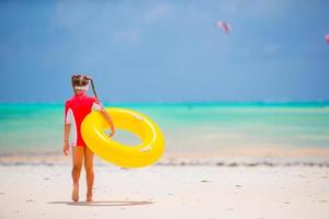 menina adorável com círculo de borracha inflável durante as férias na praia. garoto se divertindo nas férias ativas de verão foto