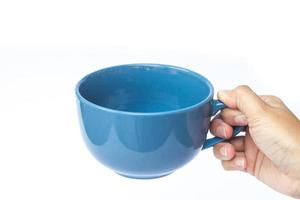 mão segurando uma caneca azul foto