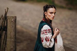 garota encantadora com vestido tradicional ucraniano caminhando foto