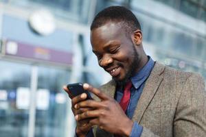 homem sorrindo enquanto envia mensagens de texto foto