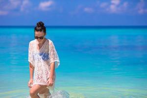 jovem mulher bonita na praia durante as férias tropicais foto