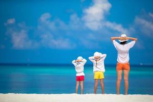 adoráveis meninas e jovem mãe na praia tropical branca foto