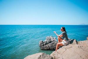 mulher turista ao ar livre na beira do penhasco à beira-mar foto