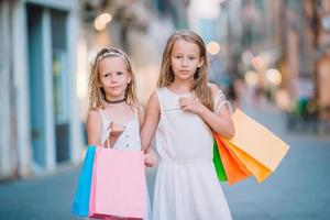 meninas muito sorridentes com sacolas de compras foto