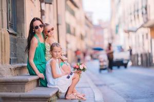 mãe com filhas bonitinhas comendo sorvete ao ar livre foto