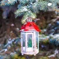 lanterna decorativa de natal no ramo de abeto na neve dia de inverno foto