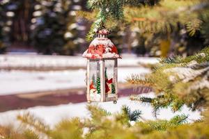 lanterna decorativa de natal no ramo de abeto na neve dia de inverno foto