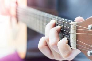 close-up de mãos em uma guitarra foto