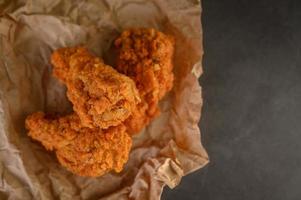 frango frito crocante em papel pardo foto