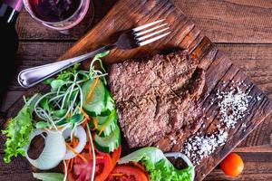 close-up de bife e em uma tábua de madeira foto