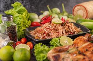 salada tailandesa de mamão rodeada de vegetais e frango