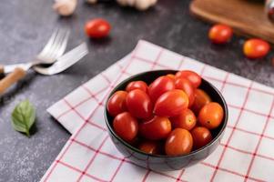 tomates maduros frescos em um pano xadrez vermelho foto