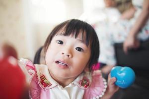 retrato de uma menina asiática brincando em sua casa foto