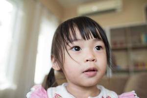 retrato de uma menina asiática brincando em sua casa foto