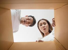 casal feliz abrindo uma caixa e olhando dentro foto