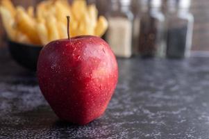 maçãs vermelhas com batatas fritas no fundo foto