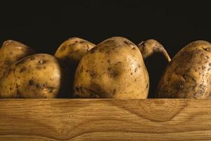 batatas em uma caixa de madeira foto
