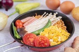 macarrão frito com milho, cogumelo dourado, tomate, linguiça e edamame foto