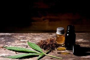 óleo de suplemento de ervas da folha de cannabis em uma velha mesa de madeira