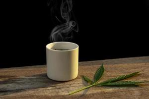 folhas verdes de maconha e xícara de chá de maconha