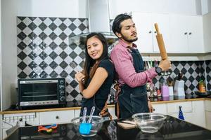 casal atraente cozinhando na cozinha de casa foto