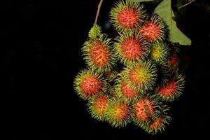 rambutans em fundo preto foto