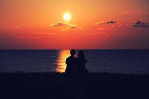 silhueta de um casal ao pôr do sol foto