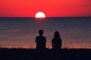 duas pessoas assistindo o pôr do sol