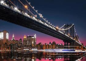 horizonte de manhattan e ponte de manhattan à noite foto