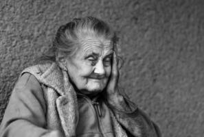 mulher enrugada muito velha e cansada ao ar livre foto