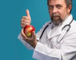 médico dando maçã para uma alimentação saudável