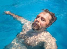 homem de meia idade em uma piscina foto