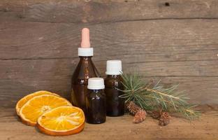 garrafa com óleos naturais de laranja, pinho e canela. conceito de aromaterapia e cosméticos naturais foto