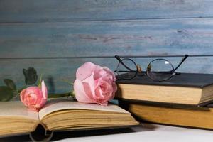 rosas cor de rosa e livros em madeira rústica foto