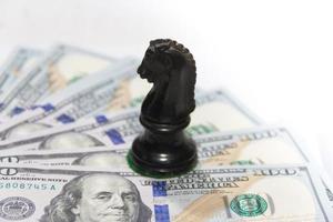conceito de finanças com notas de dólar e cavalo de xadrez foto