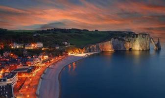 praia e vila de etretat à noite na normandia, frança foto