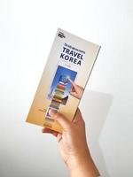 jacarta, indonésia em maio de 2022. uma mão está segurando um guia de boas-vindas para viajantes de férias na coreia foto