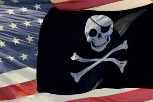 agitando a bandeira de pirata Jolly Roger na estrela e listras dos EUA foto