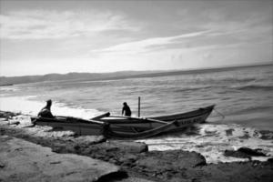 barco de pesca na praia, foto preto e branco