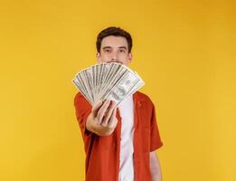 retrato de um homem alegre segurando notas de dólar sobre fundo amarelo foto