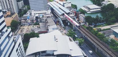 bangkok, tailândia-28 de julho de 2021 vista superior ou aérea do trem do céu na via férrea com prédio, telhado, rua ou estrada e árvore no centro de bangkok, tailândia. transporte na cidade ou no país. foto