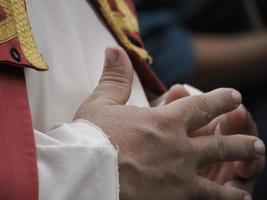 detalhe de mãos cruzadas de homem usando vestido medieval foto