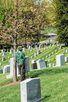 Washington DC, EUA - 2 de maio de 2014 - trabalhador está limpando lápides no cemitério de Arlington foto