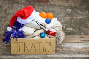 caixa de doação com roupas de inverno e com enfeites de natal. presente. foto